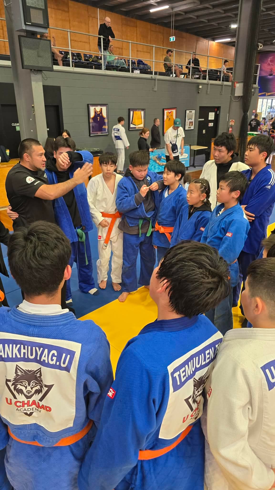 Coach briefing junior judo students at a competition