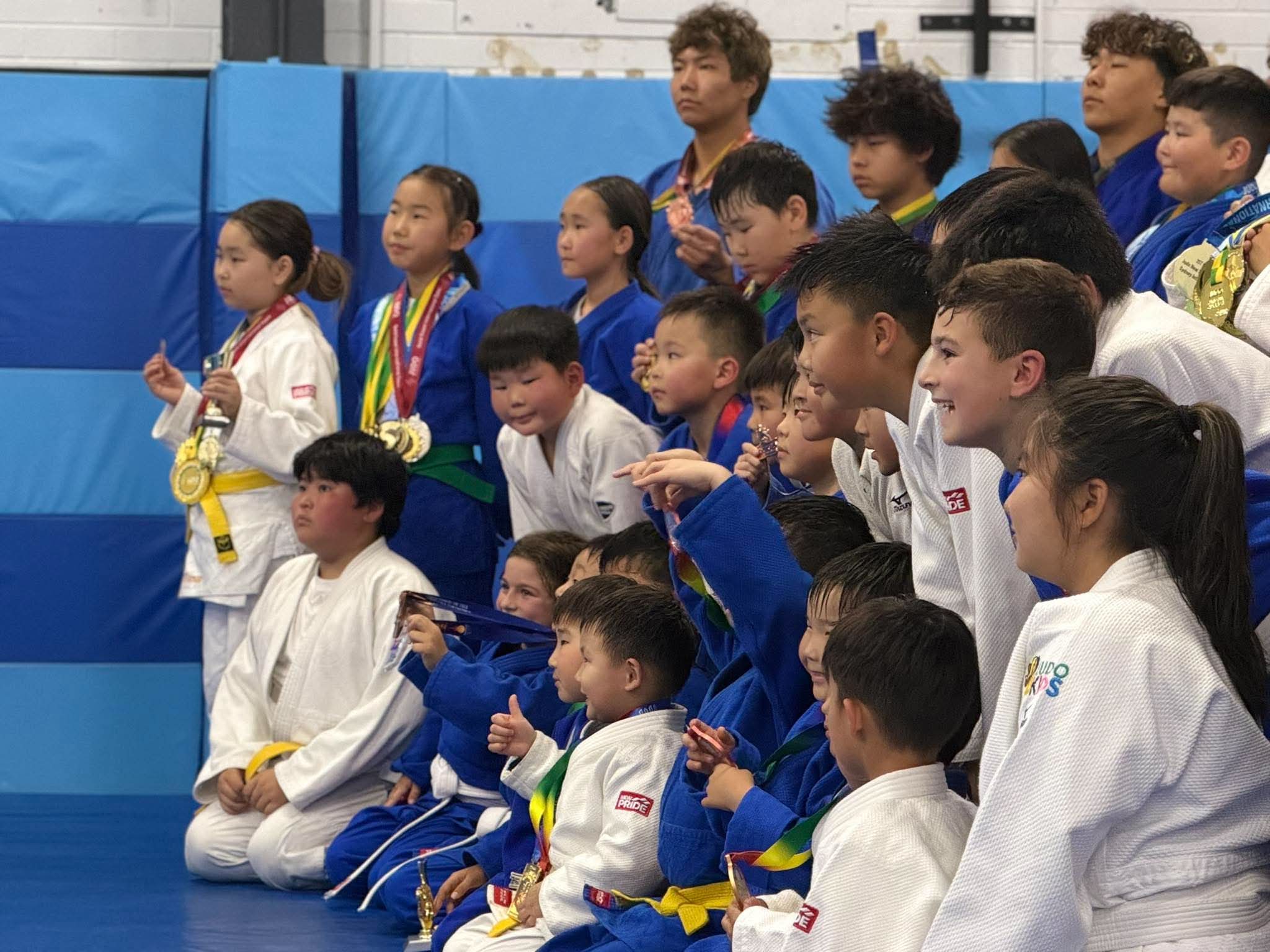 Judo students celebrating with medals